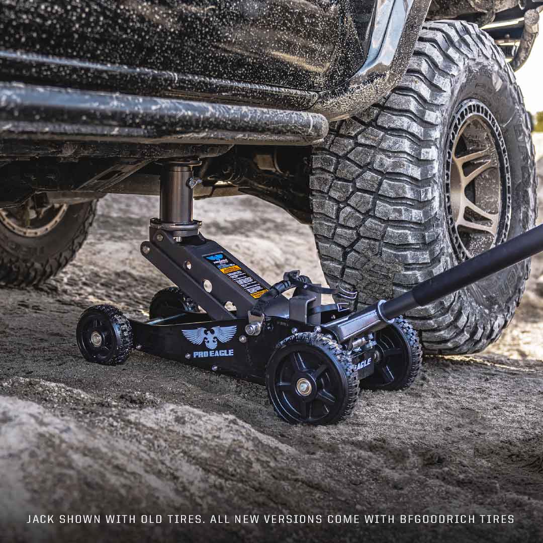 Professional 2-ton off-road jack, branded as "The Beast," positioned under a truck's chassis on a gravel surface.
