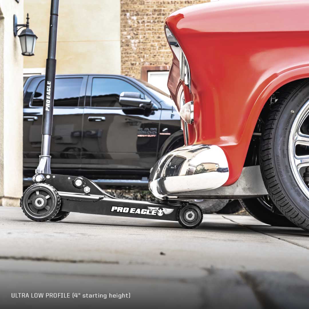 Pro Eagle 3 Ton off-road shop jack under a red classic car with a black SUV in the background.