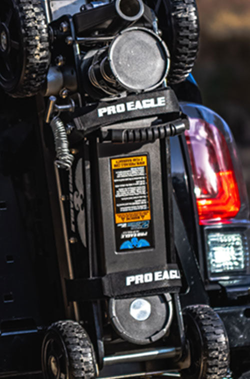 PROEAGLE off-road jack mounted on vehicle's rear with clear focus on anti-rattle strap and warning label.