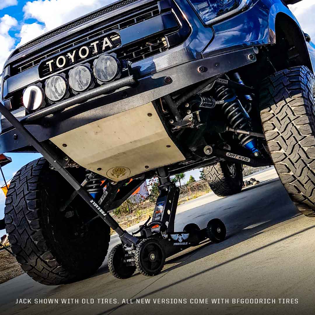 Black 2 Ton Big Wheel Off Road Jack "The Beast" under a lifted Toyota truck, showcasing its durability.
