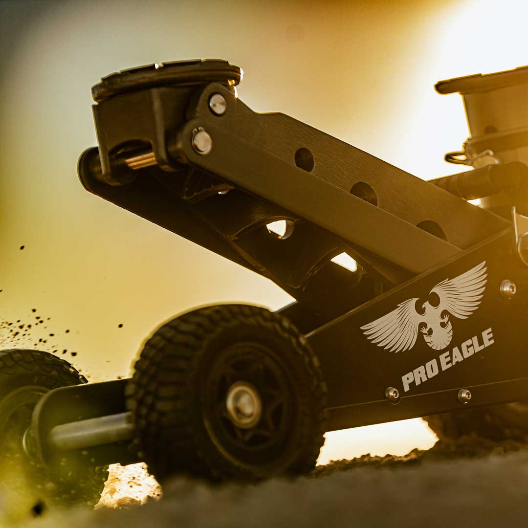 Close-up of a 2 Ton Big Wheel Off Road Jack, highlighted by a warm sunset background.