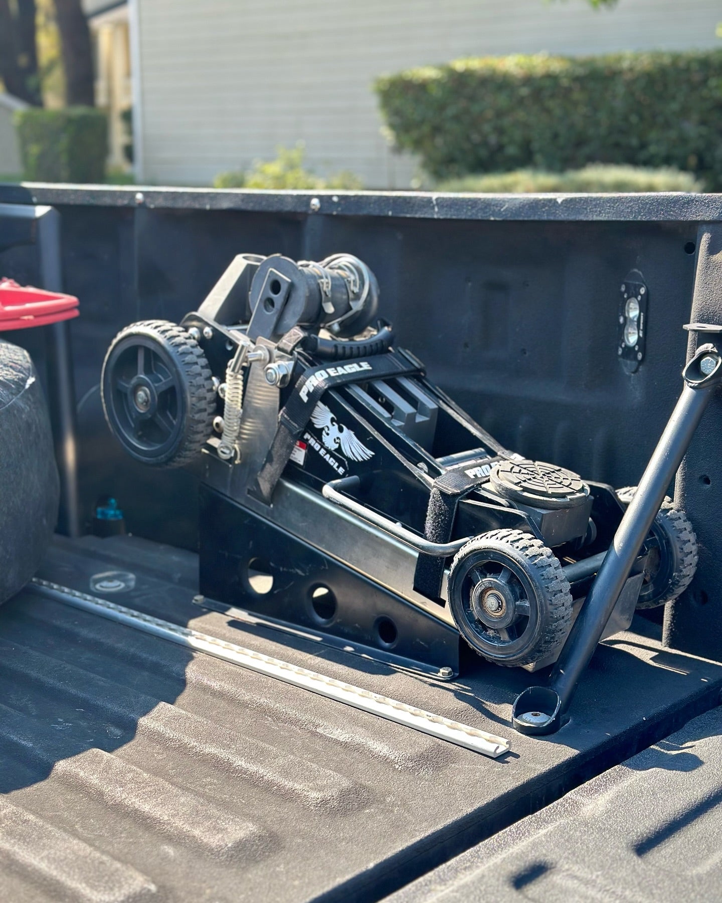 Folded wheel lift tow truck equipment in the bed of a pickup truck.